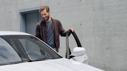 ein Mann steigt in sein neues BMW Fahrzeug