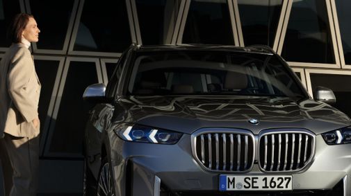 Frau steht vor silbernem BMW SAV